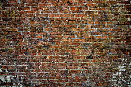 A full frame texture background of a large, worn and weathered red brick wall with copy spaceの写真素材