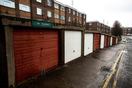 A council estate with tower blocks and rows of disused garages in the North of England during the UK Government's levelling up policyの写真素材