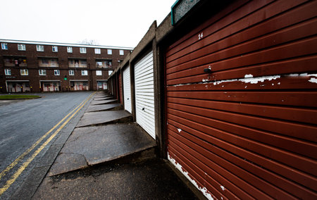 A council estate with tower blocks and rows of disused garages in the North of England during the UK Government's levelling up policyの写真素材