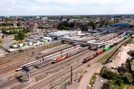 PETERBOROUGH, UK - MAY 17, 2022.  An aerial landscape view of passenger and freight trains waiting on the platforms of Peterborough train station on the East Coast Main Line railway with the city in the backgroundのeditorial素材