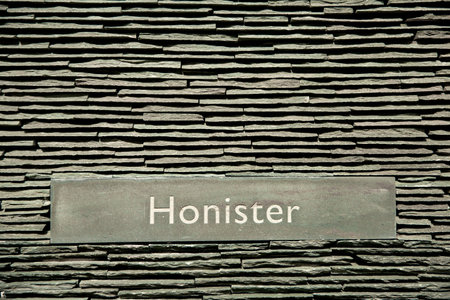A full frame background of layers of slate from Honister Slate Mine in The Lake District National Park with a Honister sign in text with copy spaceの写真素材