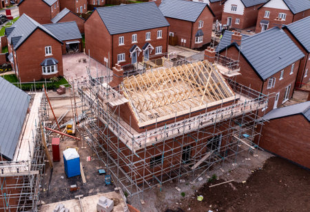 An aerial view of new build homes on a new housing estate with the roof exposed and wooden rafters and beams showingのeditorial素材