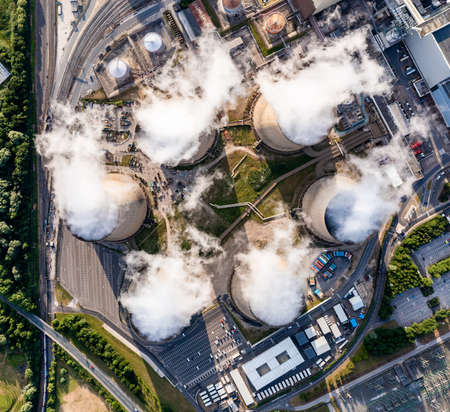 Aerial top down view of a group of cooling towers emitting steam at a large coal fired power stationの写真素材