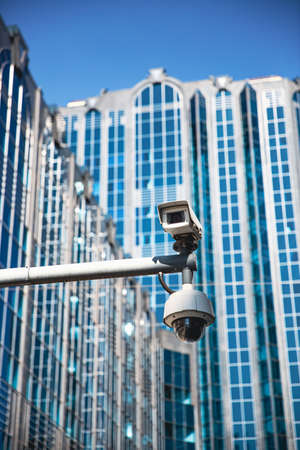 A CCTV surveillance camera on a modern city street being used for intelligence gathering and the focus of human rights liberties and crime preventionの写真素材