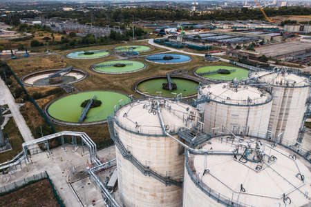 An aerial view directly above a waste water treatment works with circular storage tanks filtering...