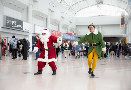 BIRMINGHAM NEC, UK - NOVEMBER 13, 2022.  A pair of male cosplayers dressed as Buddy The Elf and Santa Claus at MCM Birmingham Comic Con 2022のeditorial素材