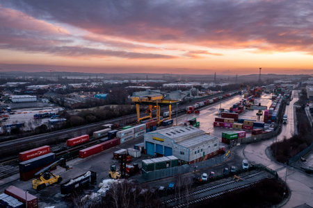 LEEDS, UK - JANUARY 19, 2023.  An aerial view of Freightliner Intermodal container terminal in Leeds at sunset with heavy machinery loading container boxes onto rail and road transportのeditorial素材