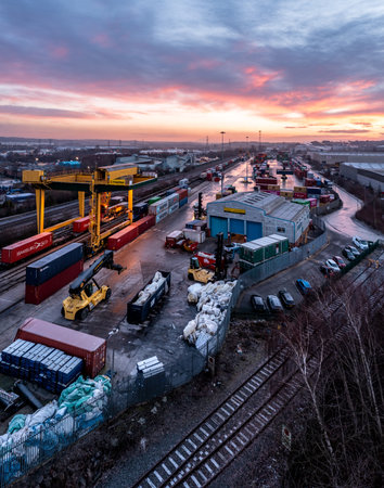 LEEDS, UK - JANUARY 19, 2023.  An aerial view of Freightliner Intermodal container terminal in Leeds at sunset with heavy machinery loading container boxes onto rail and road transportのeditorial素材