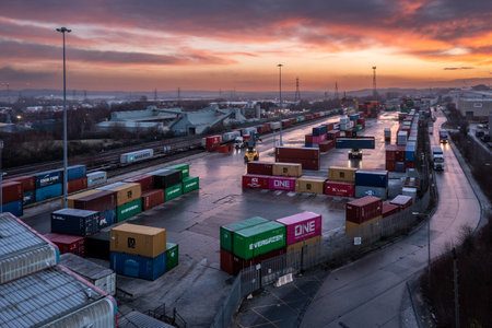 LEEDS, UK - JANUARY 19, 2023.  An aerial view of Freightliner Intermodal container terminal in Leeds at sunset with heavy machinery loading container boxes onto rail and road transportのeditorial素材