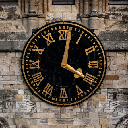 Close up of the face and hands of a traditional church clock on a clock tower in a square frameの写真素材