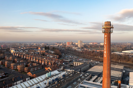 DONCASTER, UK - FEBRUARY 14, 2023.  An aerial view of Doncaster cityscape skyline at sunset with the Pegler factory chimney prominentのeditorial素材
