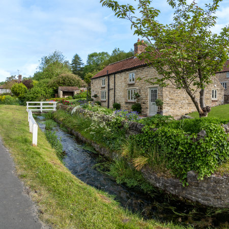 HELMSLEY, NORTH YORKSHIRE, UK - MAY 29, 2023.  Traditional stone buildings with charming cottages and small village stream running through the popular tourist destination of Helmsley in Yorkshireのeditorial素材
