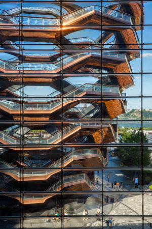 HUDSON YARDS, MANHATTAN, NEW YORK, USA - SEPTEMBER 19, 2023. Vertorama landscape of the intricate architecture of The Vessel from the window of The Shops and Restaurants skyscraper at Hudson Yards in New York City at sunsetのeditorial素材