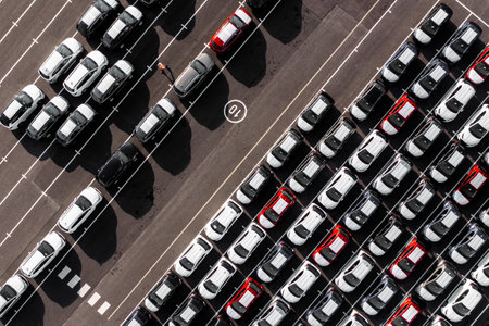 An aerial view directly above rows of newly built cars in the automobile industry on a commercial...