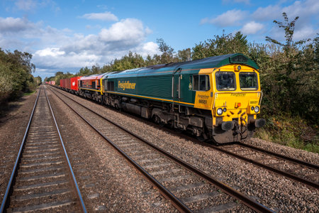 BURTON UPON TRENT, UK - OCTOBER 3, 2023.  Two Freightliner Intermodal Class 66 freight locomotives towing a shipping container box train through the English countrysideのeditorial素材