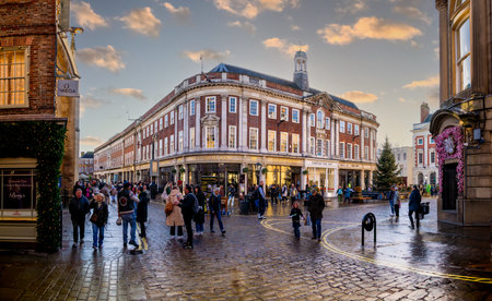 ST HELENS SQUARE, YORK, UK - NOVEMBER 17, 2023.  Shoppers and crowds of people walking through York city centre at Christmas with Betty's Cafe and Tea Room buildingat sunsetのeditorial素材