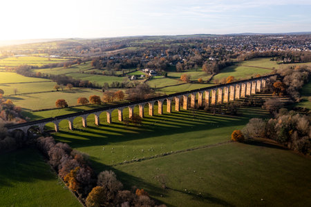 An aerial landscape high above the historic Crimple Valley Viaduct bridge with multiple arches near the Yorkshire Dales town of Harrogate at sunsetの写真素材