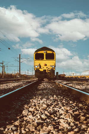 Low angle point of view of a goods rail locomotive approaching on railway tracks and sleepers with copy spaceの写真素材