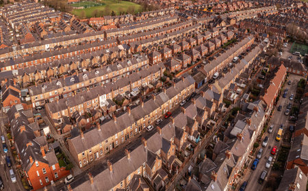 An aerial view above the rooftops of run down back to back terraced houses on a large residential estate in the North of Englandの写真素材
