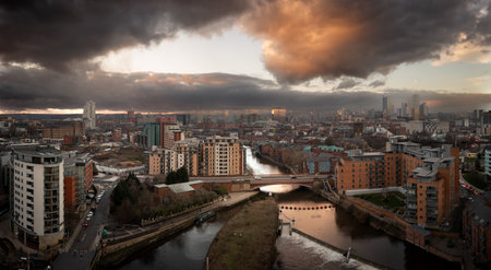 An aerial panoramic view of Leeds cityscape skyline with Leeds Dock and the River Aire running through the city with dramatic sky at sunriseの写真素材