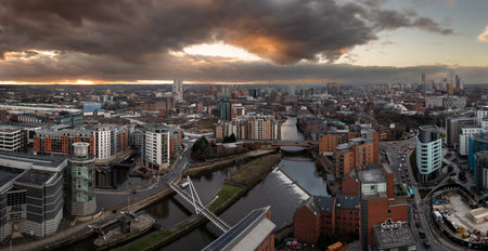 An aerial panoramic view of Leeds cityscape skyline with Leeds Dock and the River Aire running through the city with dramatic sky at sunriseの写真素材