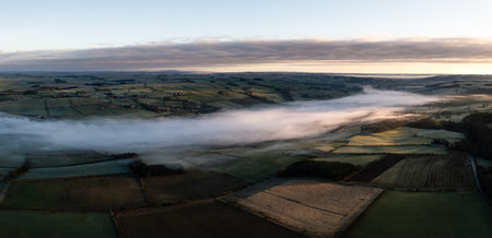 Aerial view of low lying mist or cloud inversion along the River Tyne valley at Haydon Bridge near Hexham on a cold Winter morningの写真素材