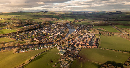 An aerial panoramic landscape of the village of Haydon Bridge in the Northumberland National Park with the River Tyne running throughの写真素材