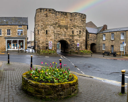 ALNWICK, NORTHUMBERLAND, UK - APRIL 22, 2024.  A landscape view of the ancient Bondgate Tower which is a gatehouse leading to Bondgate Within in Alnwick town centre in Northumberlandのeditorial素材