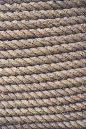 A full frame background of thick shipping rope tightly wrapped together and made from durable natural fibres such as Jute in a vertical orientation with copy spaceの写真素材