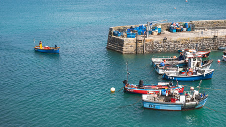 COVERACK, CORNWALL, UK - JUNE 15, 2024. A local Cornish fisherman in a traditional small fishing boat arriving with the catch of the day into Coverack Harbour in Cornwall, UKのeditorial素材