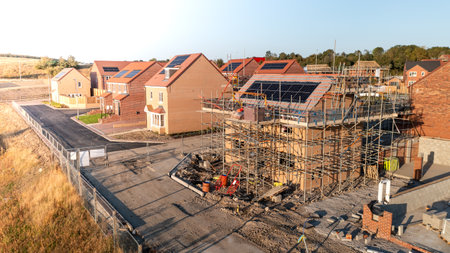 Aerial view of new build energy efficient and eco friendly homes with integrated rooftop solar panels generating renewable domestic energy on a house building developmentの写真素材