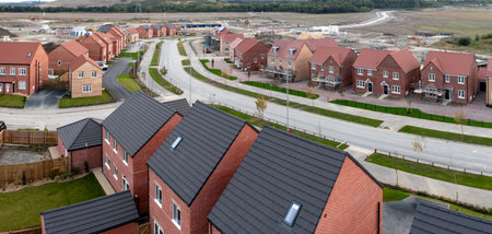 Aerial panoramic landscape view of a new build housing estate with houses under construction to fill the gap in the UK home shortage and supplement the UK Government's Right To Buy policy on a brownfield siteの写真素材