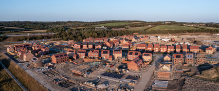 Aerial panoramic landscape view of a new build housing estate with houses under construction to fill the gap in the UK home shortage and supplement the UK Government's Right To Buy policyの写真素材