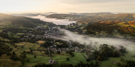 Aerial panoramic landscape of the Lake District town of Ambleside with Windermere lake on a cold Autumn morning with low lying misty conditionsの写真素材