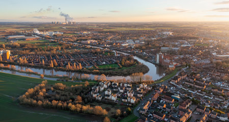 Aerial panoramic landscape of the River Ouse flowing through the North Yorkshire market town of Selby with Drax Power Station in the distance and dramatic sunsetの写真素材