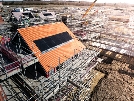The roof of a new build houseunder construction on a construction site with roof integrated or In-Roof solar panels for cheap and sustainable energy in an eco friendly propertyの写真素材