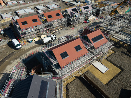 The roof of a new build houses under construction on a construction site with roof integrated or In-Roof solar panels for cheap and sustainable energy in an eco friendly propertyの写真素材
