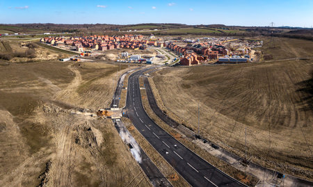 Aerial view of affordable new build houses on a construction site on green belt land with new road infrastructure creating new town in the UKの写真素材