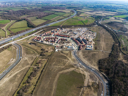 Aerial view of affordable new build houses on a construction site on green belt land with new road infrastructure creating new town in the UKの写真素材