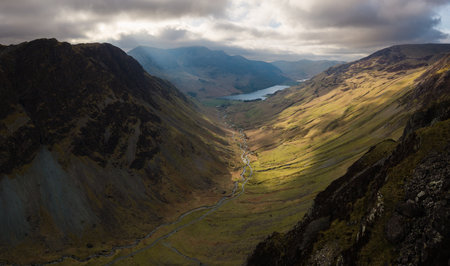 Dramatic aerial panorama landscape view of the Honister Pass road in The English Lake District National Park in Cumbria, UK with surrounding mountains winding it's way to Buttermere Lakeの写真素材