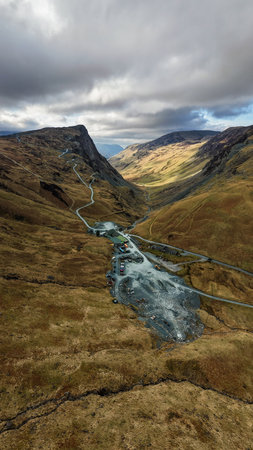 Aerial vertical panorama landscape view of the Honister Slate Mine and Pass road in The English Lake District National Park in Cumbria, UK with surrounding mountainsの写真素材