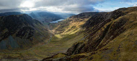 Dramatic aerial panorama landscape view of the Honister Pass road in The English Lake District National Park in Cumbria, UK with surrounding mountains winding it's way to Buttermere Lakeの写真素材
