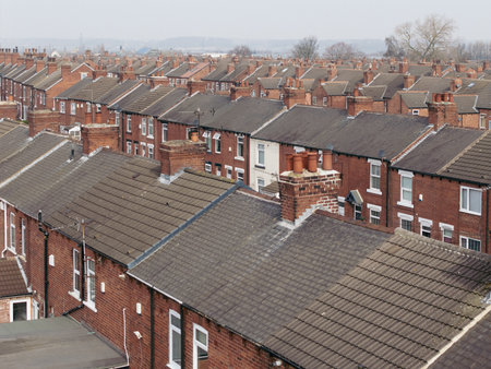 An aerial view above the rooftops of run down back to back terraced houses on a large residential estate in the North of Englandの写真素材