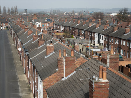 An aerial view above the rooftops of run down back to back terraced houses on a large residential estate in the North of Englandの写真素材