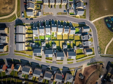 Aerial top down view above a block of newly built affordable suburban homes in the UK with small gardens and built on green belt land due to a housing shortageの写真素材
