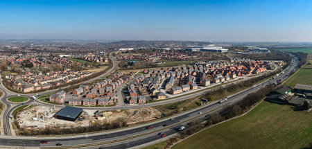 Aerial panorama landscape view of a large new build housing development on the edge of a UK city and built on green belt land due to a housing shortage with road transport linksの写真素材