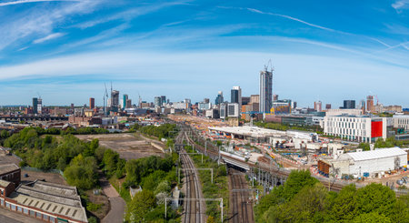 An aerial panoramic view of Birmingham cityscape skyline with the HS2 construction site and railway tracks running alongside University buildings on Curzon Streetの写真素材