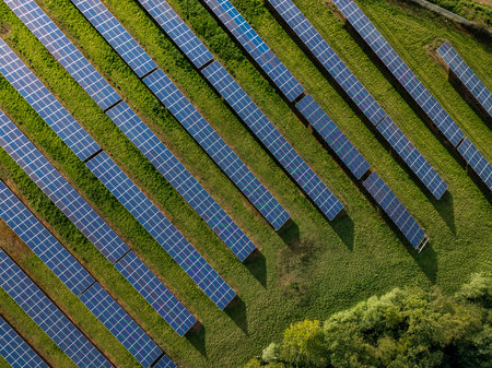 Rows of photovoltaic solar panels on agricultural land generating clean sustainable energy for business and domestic purposesの写真素材