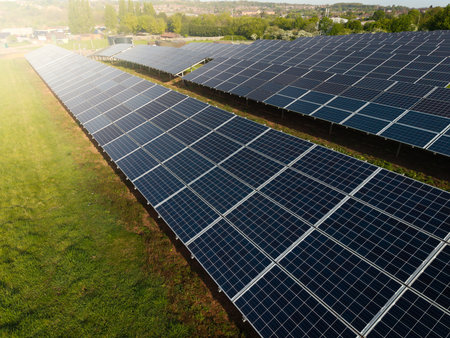 Rows of photovoltaic solar panels on agricultural land generating clean sustainable energy for business and domestic purposesの写真素材