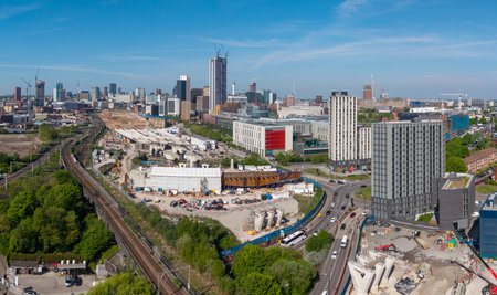 An aerial panoramic view of Birmingham cityscape skyline with the HS2 construction site and railway tracks running alongside University buildings on Curzon Streetの写真素材